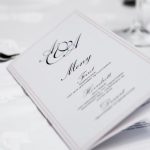 Close-up of a refined dining table with menu and silverware, showcasing elegance in a formal restaurant setting.